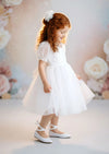 Sheer tulle skirt and lace bodice on elegant white communion and baptism dress