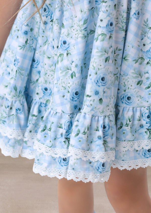 Close-up of a light blue floral dress with lace trim.