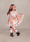 Toddler girl floral dress with orange flowers on a beige background