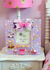 Handmade 11x11" lavender birthday photo frame with pastel floral paper, 3D cake & cupcake accents, ribbon bow, glass insert, and easel back. Holds 5x5" photo. One-of-a-kind and designer-signed.