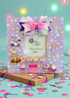 Handmade 11x11" lavender birthday photo frame with pastel floral paper, 3D cake & cupcake accents, ribbon bow, glass insert, and easel back. Holds 5x5" photo. One-of-a-kind and designer-signed.