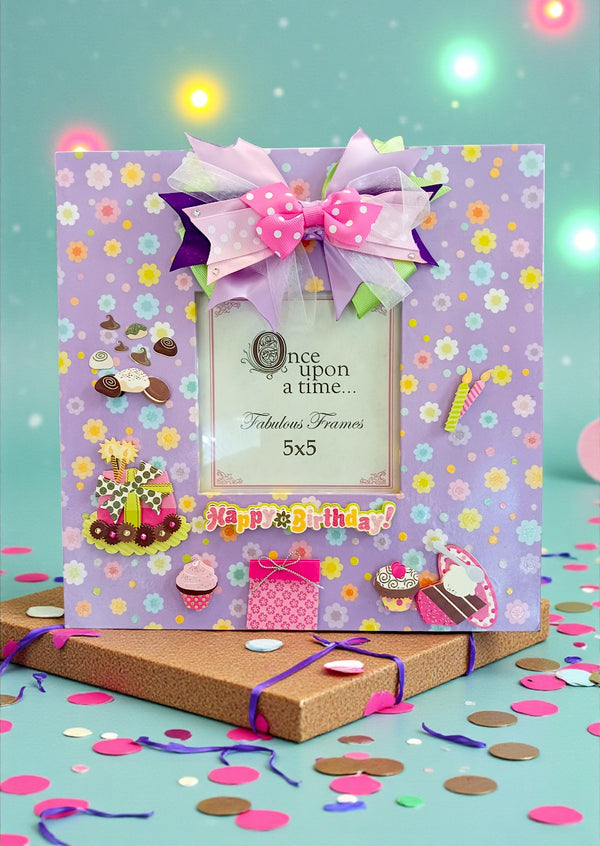 Handmade 11x11" lavender birthday photo frame with pastel floral paper, 3D cake & cupcake accents, ribbon bow, glass insert, and easel back. Holds 5x5" photo. One-of-a-kind and designer-signed.