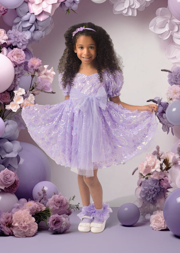 Toddler girl in lavender party dress with puff sleeves, 3D floral appliqués, and sparkling sequins