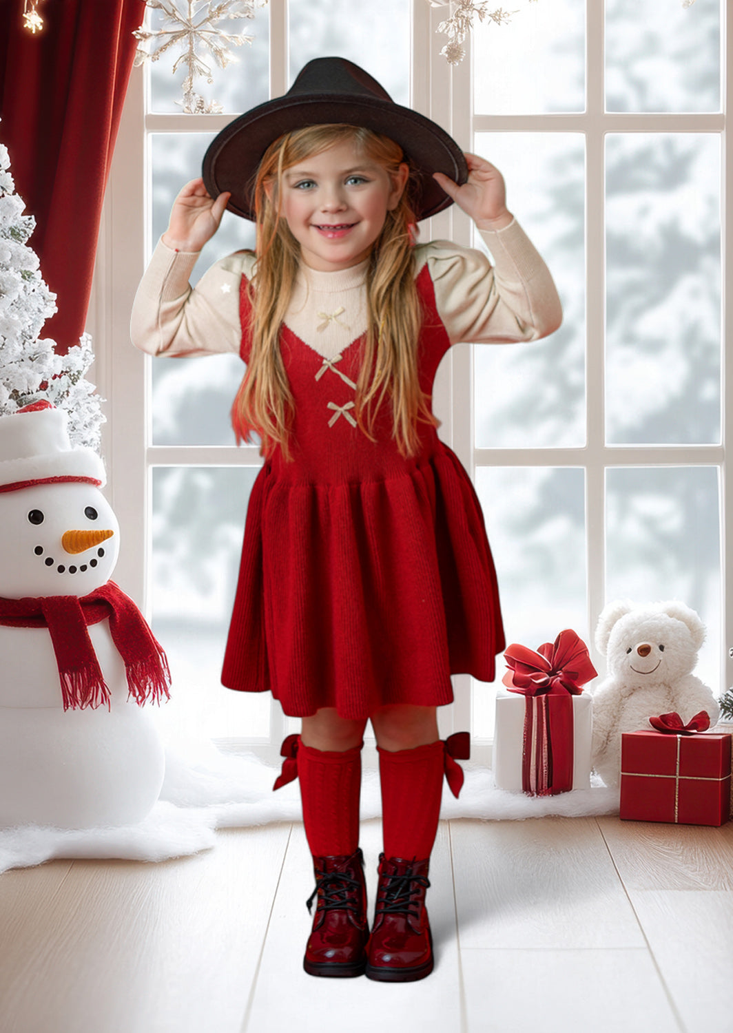 Child in a red dress and black hat standing in a festive room with a snowman, teddy bear, and presents.