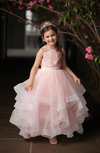 Little girl wearing a pink cascading gown with lace bodice and floor-length skirt