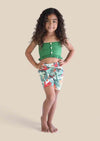 Woman wearing green button top with tropical floral high-waisted shorts set outdoors