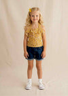 Yellow floral halter top with ruffles paired with dark-wash denim shorts summer outfit